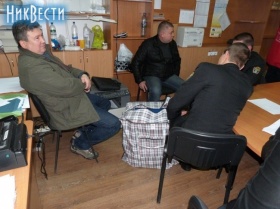 экс-нардеп от Майборода (слева), Анатолий Марчук (в черной куртке) и двое ГИСовцев стерегут сумку с протоколами