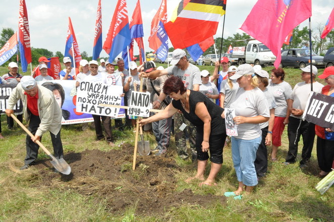 Депутат областного совета А.Павлова ставит крест на могиле НАТО