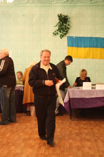 Владимир Чайка получил бюллетени и направляется в кабинку для голосования