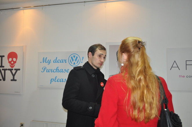 Посетители выставки оживленно обсуждают работы автора