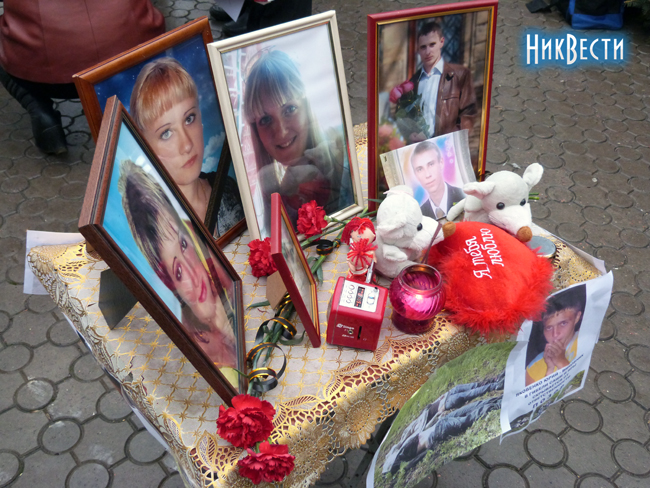 Митингующие разместили на столике фото погибших детей, свечки и их игрушки Митингующие разместили на столике фото погибших детей, свечки и их игрушки
