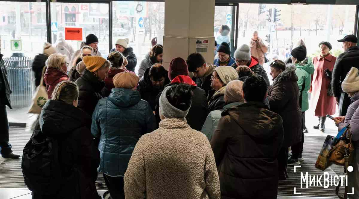 Kø af mennesker, der venter på at oplade telefoner i en butik under strømafbrydelse