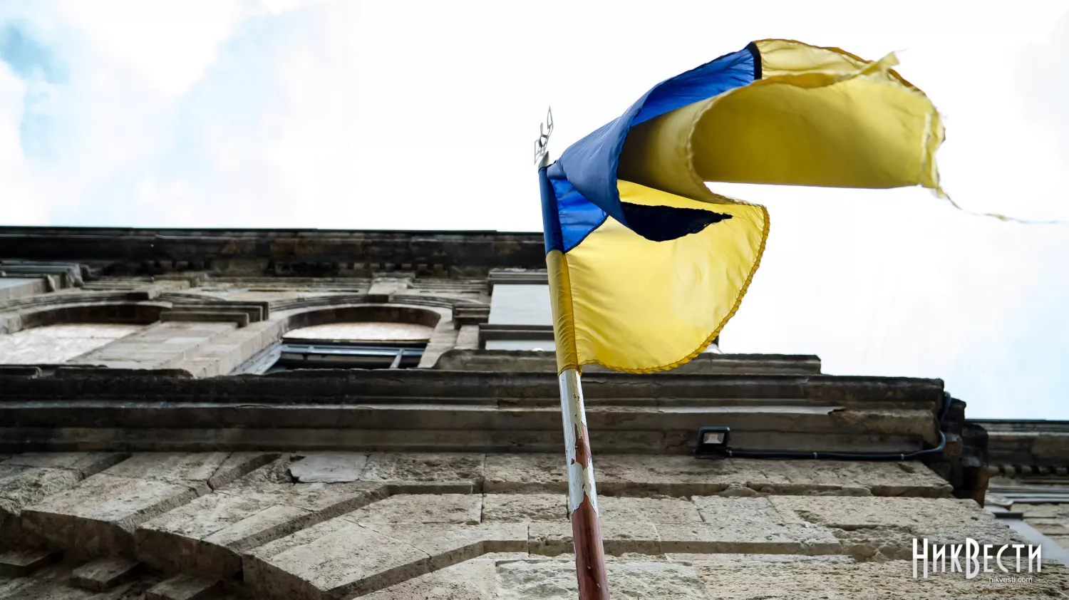 The Ukrainian flag against the background of the destroyed building of the Mykola Arkas gymnasium in Mykolaiv, April 23, 2024, photo: Serhiy Ovcharyshyn, «NikVesti"