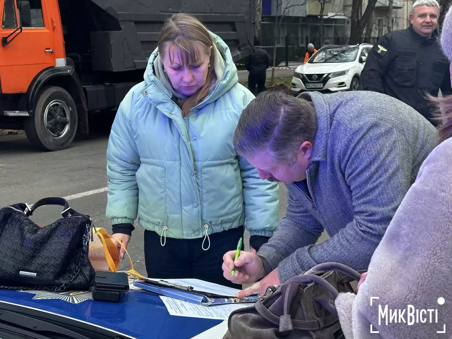 Екоінспекторка Наталія Барчук та представник власниці будівлі підписує протокол, який йому вручили. Фото: «НикВести»