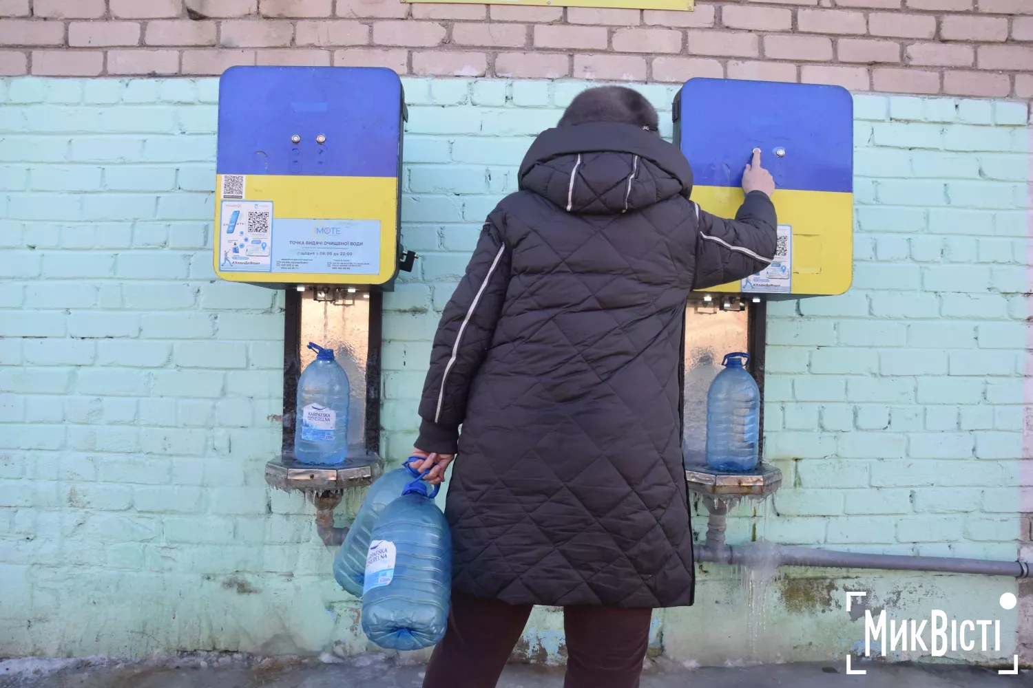 Люди наповнюють пляшки на пунктах видачі питної води 19 січня. Фото: МикВісті