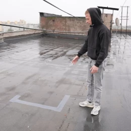 Максим заклеїв стики на даху, щоб квартиру знов не затопило. Фото: Суспільне. Миколаїв