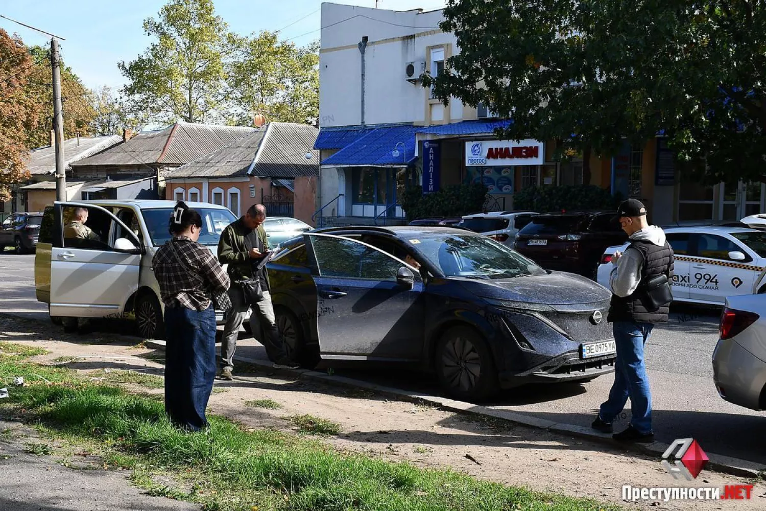 Співробітники з шевронами НАБУ біля автомобіля Nissan у центрі Миколаєва. Фото: ПН