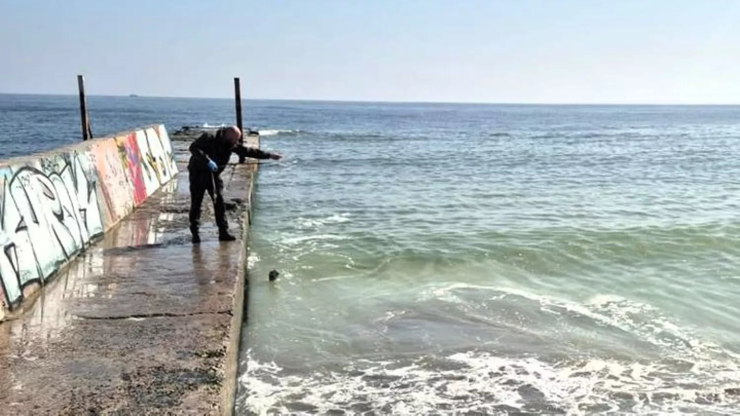 Інспектор бере проби морської води біля узбережжя Одеси для лабораторного аналізу забруднення олією. Фото: Держекоінспекція
