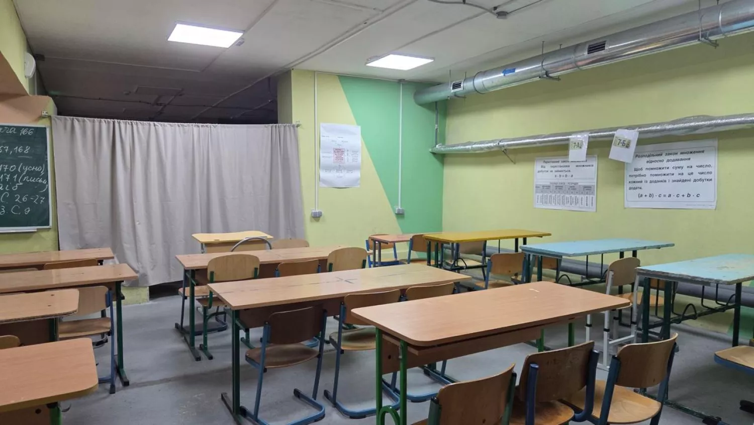 Журналісти показали шкільне укриття у Миколаєві: класи розділені шторами, діти по троє за партою. Фото: Суспільне Миколаїв