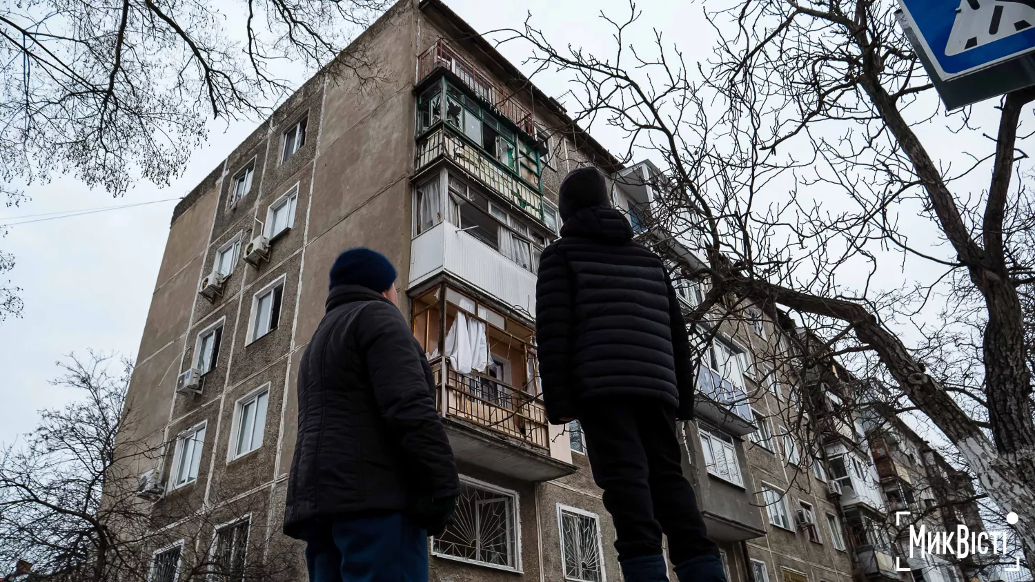 Миколаївці навпроти будинку, який пережив ворожий обстріл, 16 лютого 2025 року. Фото: Сергій Овчаришин, «МикВісті»